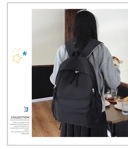 Rear view of a black minimalist nylon backpack with side pockets and woven zip details