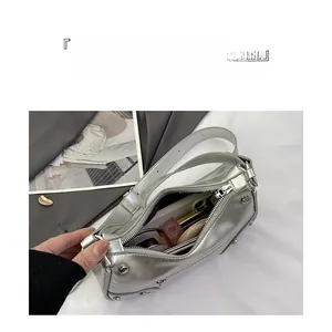 Internal storage view of silver rivet dumpling bag with phone and cosmetics