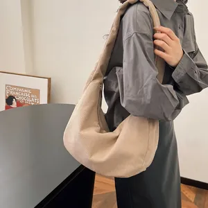 Detail of beige corduroy shoulder bag with soft ribbed texture and side zipper