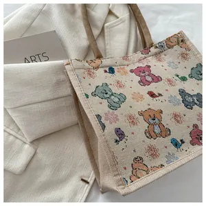 Détail du sac cabas en toile avec oursons colorés et poignées en corde tressée marron