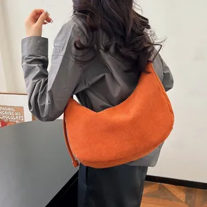 Detail of orange corduroy hobo bag with zip tassel and soft ribbed fabric texture