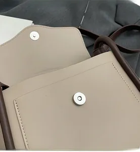 Vista dettagliata della borsa beige con chiusura magnetica invisibile e cuciture di precisione