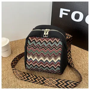 Detail of colorful ethnic pattern mini bag with golden zippers and geometric strap