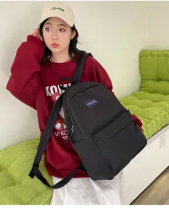 Nahaufnahme des schwarzen Nylon-Rucksacks mit strapazierfähigen Gurten und blauem Label