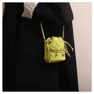 Detail der neongrünen gesteppten Mini-Beuteltasche mit Goldkette und Herz-Anhänger