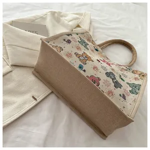 Détail du sac cabas en lin écologique avec motifs colorés d'animaux et de fleurs