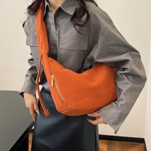 Close-up of orange corduroy crossbody bag with soft texture and golden zipper detail