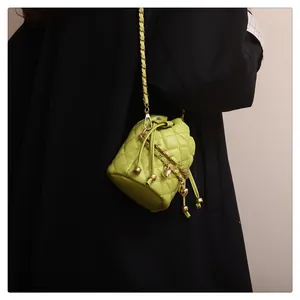 Detailansicht der grünen gesteppten Beuteltasche mit goldener Kette und Kordelzugverschluss