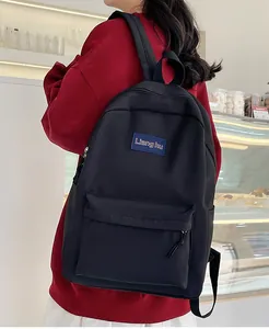Detail eines schwarzen Nylon-Rucksacks mit kontrastierendem Markenlabel und Fronttasche