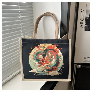 Close-up of a jute tote bag with a vibrant blue dragon print and woven handles