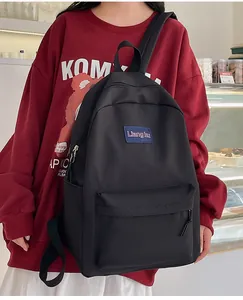 Model mit einem großen minimalistischen schwarzen Nylonrucksack und Reißverschluss