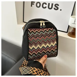 Close-up of bohemian canvas bag with colorful wavy weave and gold dual zippers