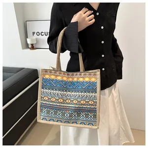 Detail of bohemian jute tote bag featuring colorful geometric patterns and woven handles