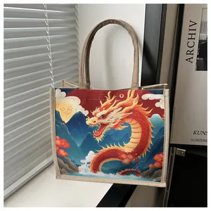 Detail of canvas tote bag featuring a vibrant red Chinese dragon and mountain illustration