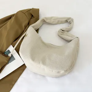 Macro detail of high-quality corduroy texture on minimalist off-white hobo shoulder bag