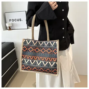 Detail shot of bohemian geometric jute tote bag with ethnic pattern and woven handles