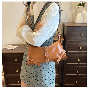 Bruine retro schoudertas met zilveren metalen gespen in een vintage lifestyle setting