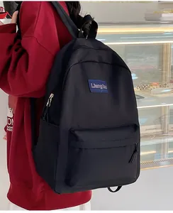 Detailansicht des schwarzen Rucksacks aus strapazierfähigem Stoff mit blauem Logo-Patch