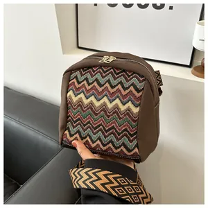 Detail of retro ethnic canvas crossbody bag with colorful zigzag knit pattern and zipper