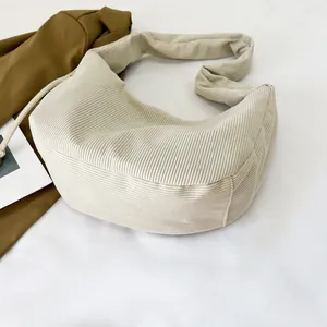 Detail of beige corduroy hobo bag showing thick ribbed texture and drawstring design