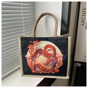 Close-up of black canvas tote bag featuring a red dragon print and linen handles