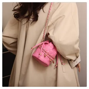 Detail der rosa gesteppten Beuteltasche mit goldener Herzkette und Kordelzugverschluss
