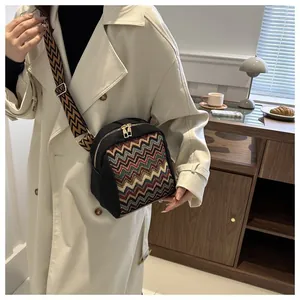 Ethnic crossbody bag featuring colorful wave embroidery on black canvas with a wide strap