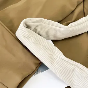Close-up of white corduroy fabric texture and strap detail on a casual shoulder bag