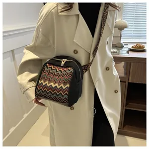 Ethnic crossbody bag with chevron patterned strap shown in a stylish lifestyle setting