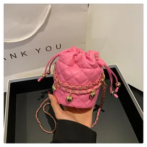 Detailansicht der rosa gesteppten Mini-Beuteltasche mit Herzanhänger und Kettenriemen