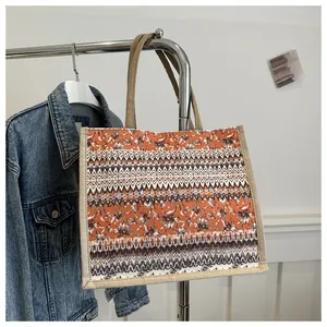 Detail of bohemian linen tote bag with geometric floral patterns and sturdy brown handles