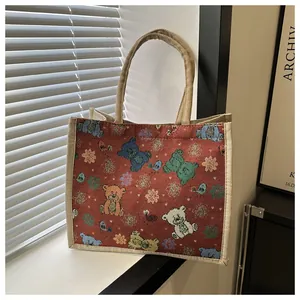 Gros plan du sac en toile rouge avec motifs d'ours tissés et poignées en corde