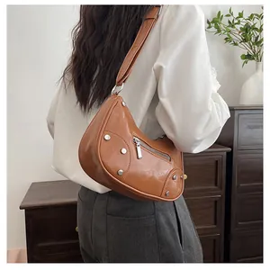 Close-up of brown vintage hobo bag with silver rivets and metallic zipper detail