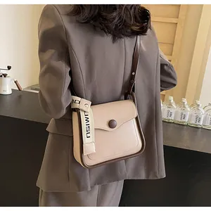 Dettaglio borsa a mano beige in similpelle con bordi marroni e cinturino in tessuto NSIWN