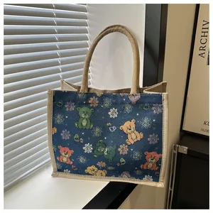 Vue détaillée du cabas en toile marine avec motifs d'ours colorés et anses en jute