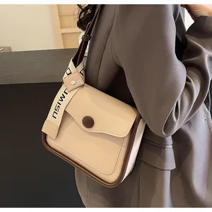 Dettaglio della borsa a tracolla in PU beige con bordo marrone e accento MISU