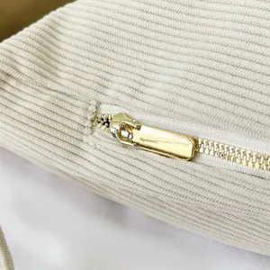 Detail of premium beige corduroy texture and high-quality gold metal zipper closure