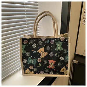 Détail d'un petit sac en lin noir avec oursons colorés et anses en chanvre tressé