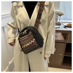 Close-up of retro ethnic crossbody bag with colorful woven patterns and gold zippers