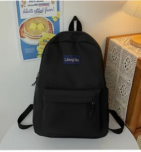Nahaufnahme des schwarzen Nylon-Rucksacks mit blauem Etikett in wohnlicher Atmosphäre