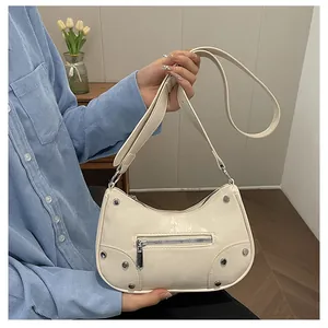 Close-up of cream vintage dumpling bag with silver studs and zipper detail