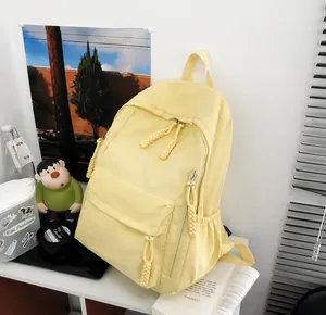 Close-up of yellow large school backpack with dual zippers and front pocket on desk