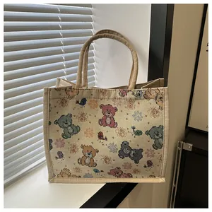 Détail du sac en lin avec motifs d'ours mignons et poignées texturées robustes