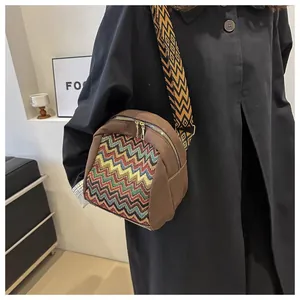 Close-up of brown vintage crossbody bag with colorful woven pattern and wide strap