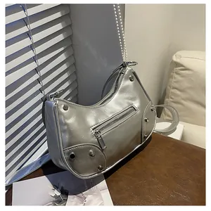Detail view of silver rivet hobo bag featuring pleats and decorative pearl chain strap