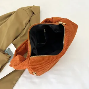 Caramel corduroy drawstring shoulder bag with golden hardware and interior zip pocket