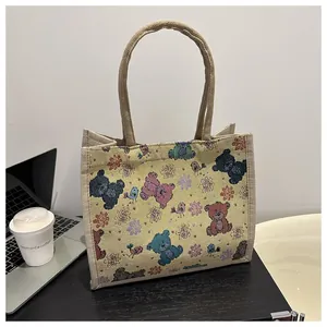 Détail du sac cabas en lin tissé avec motif jacquard d'ours et poignées en corde