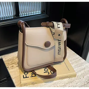 Dettaglio borsa a tracolla bicolore con tracolla jacquard logo e profili in pelle marrone