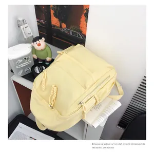 Close-up of yellow nylon backpack with multi-zipper layers and woven rope pullers