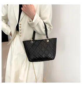 Détail d'un sac cabas matelassé noir avec bandoulière chaîne dorée et anses chic